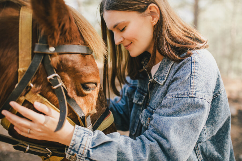 A young woman hugging a horse