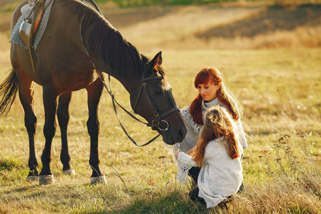 Mother and daughter with a horse in a field