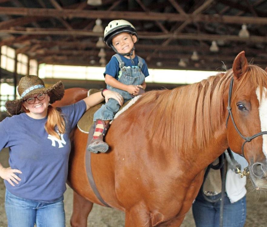 Mother and son smiling on a horse